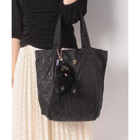 [型番：315541]チャームとしてバッグに着けることも可能な、猫のティティぬいぐるみポーチに入れて持ち運びができるエコバッグは、アナスイのオリジナルプリント生地で出来ています。トーンonトーンでプリントされているので、無地ライクにお持ちいただけます。バッグのフロントにはゴールドプリントでアナスイのロゴをアクセントに。黒ネコには黒のバッグ、グレーネコにはパープルのバッグが付属しています。